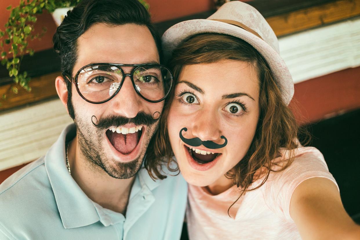 couple making funny selfie with mustaches