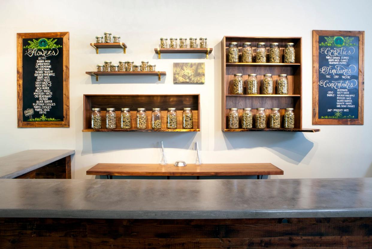 Jars of marijuana and menu boards behind the counter at a marijuana dispensary