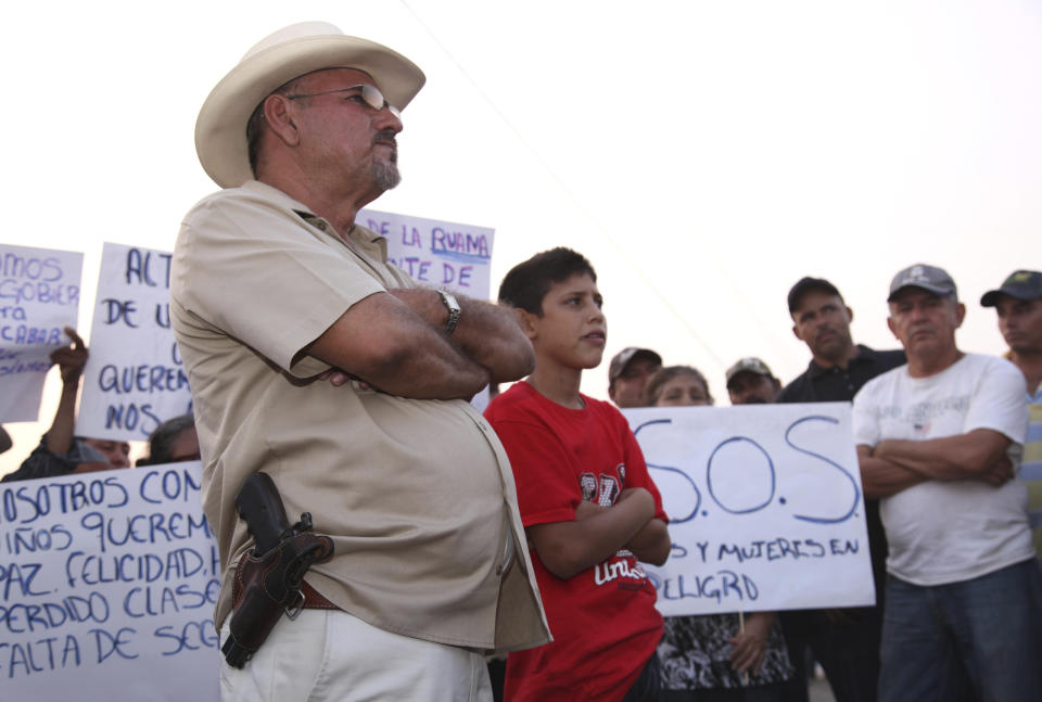 FILE - Hipolito Mora, leader of a local self-defense movement, stands with a side-arm as residents protest extortion fees and kidnappings by the Knights of Templar drug cartel in La Ruana, Mexico, May 19, 2013. Mora has been killed on Thursday, June 29, 2023, in a successful attempt on his life. (AP Photo/Marco Ugarte, File)