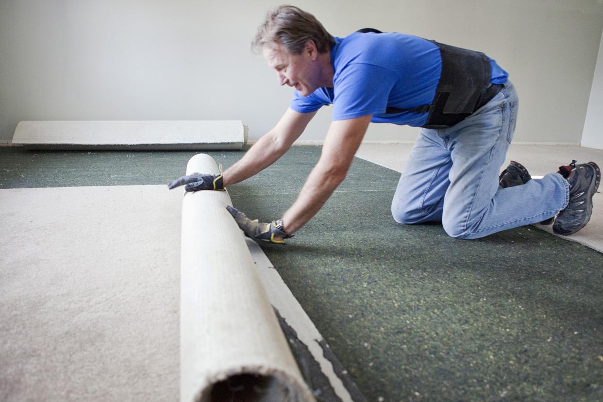 man tearing out carpet