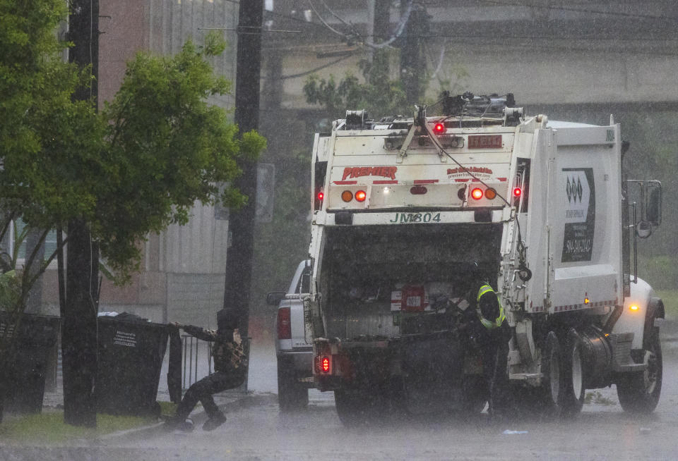Heavy rains fall and water on the street rises as sanitation crews pick up trash in New Orleans on Wednesday, April 10, 2024. Severe thunderstorms were expected across parts of the Louisiana, Mississippi, Alabama and the Florida panhandle and there was the potential for tornadoes, a few of which may be strong, and damaging winds, which may exceed 75 mph (120 kph), the National Weather Service warned.(Chris Granger /The Times-Picayune/The New Orleans Advocate via AP)