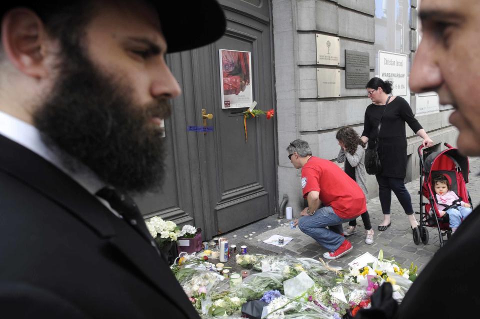 Passers-by put down flowers at the entrance of the Jewish Museum, site of a shooting in central Brussels