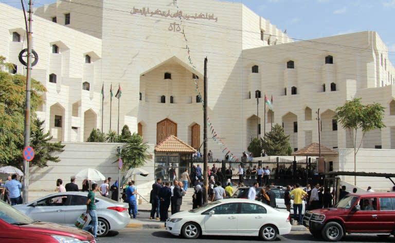 Jordanian police and onlookers gather at the scene where prominent writer Nahed Hattar was shot dead outside a court in Amman on September 25, 2016