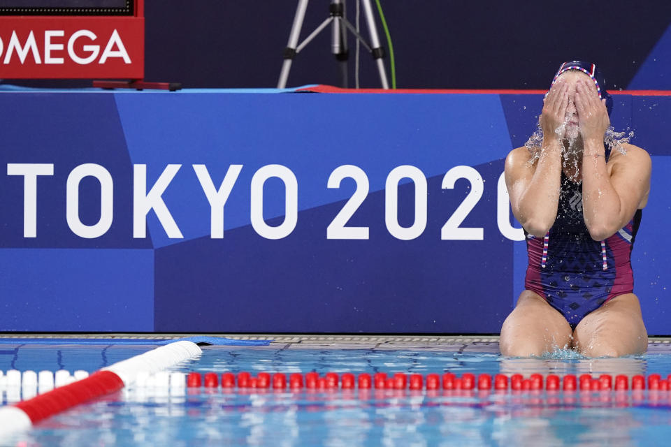 Anastasia Simanovich, of the Russian Olympic Committee, splashes water on her face as she sits on the side of the pool following an 18-5 loss to the United States during a preliminary round women's water polo match at the 2020 Summer Olympics, Friday, July 30, 2021, in Tokyo, Japan. (AP Photo/Mark Humphrey)