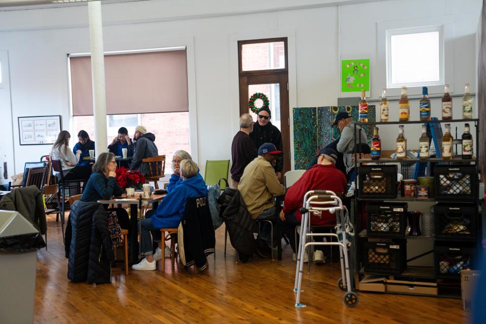 Community members gather at Perry Perk, a local coffee shop, on Friday morning after a shooting a Perry High School. A sixth grade student died, and four students and three school staff were injured.