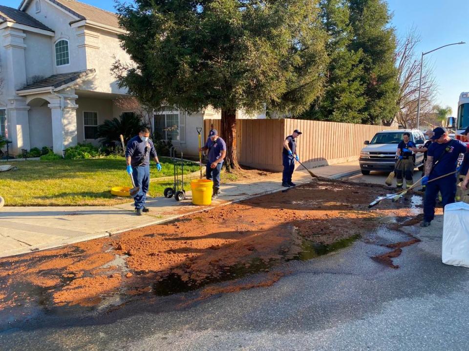 Crews put absorbent on chemicals after a city of Fresno garbage truck caught on fire on Wednesday, Jan. 26, 2022.