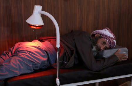 A displaced Syrian refugee attends a session at a physiotherapy clinic inside a large tent in the border village of Shamarin