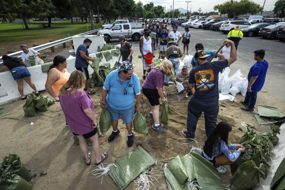 In preparation for the approaching Hurricane Hilary, residents of San Bernardino, Ca., fill sandbags at Wildwood Park on Saturday, Aug. 19, 2023, with a line forming as they wait their turn. (Watchara Phomicinda/The Orange County Register via AP)