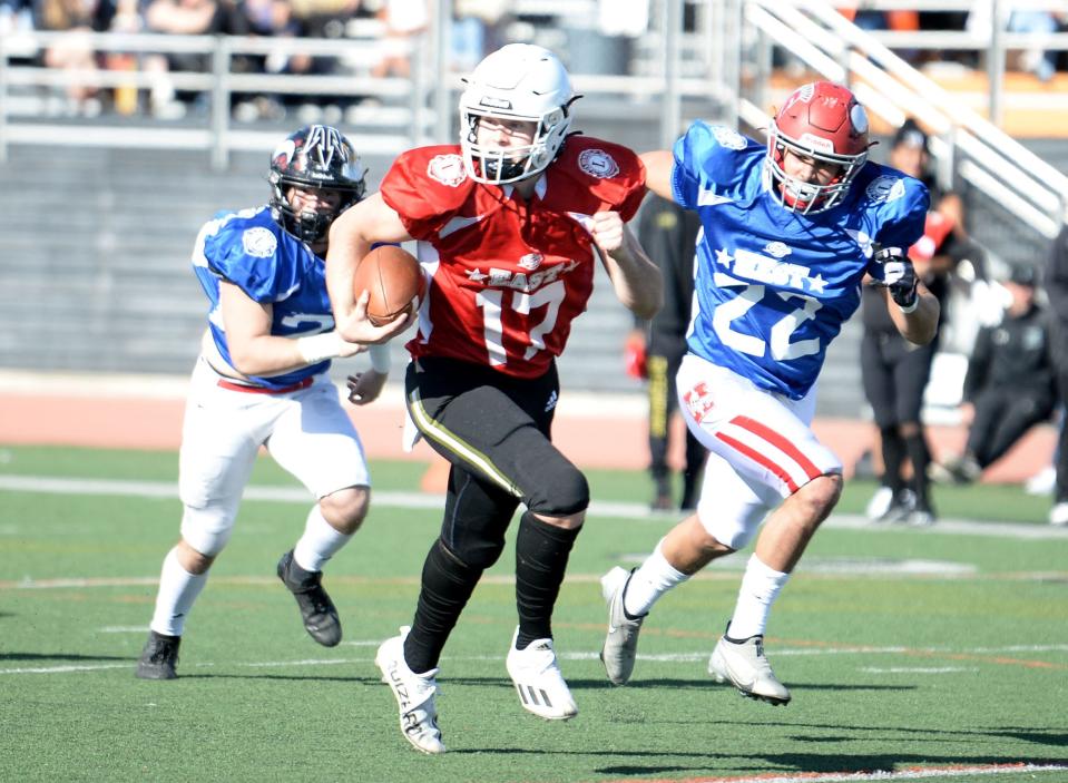 East All-Star quarterback Kadyn Parr of Oak Park runs away from West All-Star Manuel Campos-Cisneros of Hueneme (22) during the 49th annual Ventura County All-Star Football Game at Ventura College on Saturday, Feb. 4, 2023. The East won, 39-25.