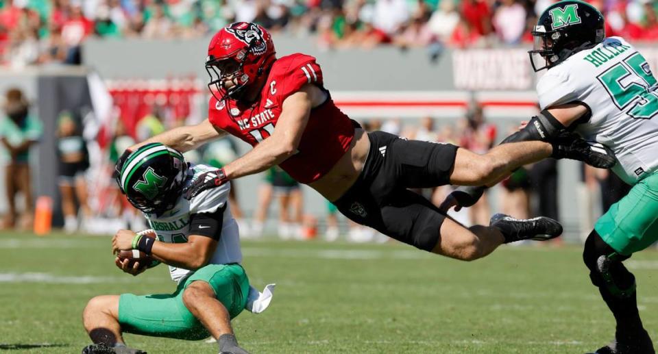 N.C. State linebacker Payton Wilson (11) tackles Marshall quarterback Cam Fancher (14) during the first half of N.C. State’s game against Marshall at Carter-Finley Stadium in Raleigh, N.C., Saturday, Oct. 7, 2023.