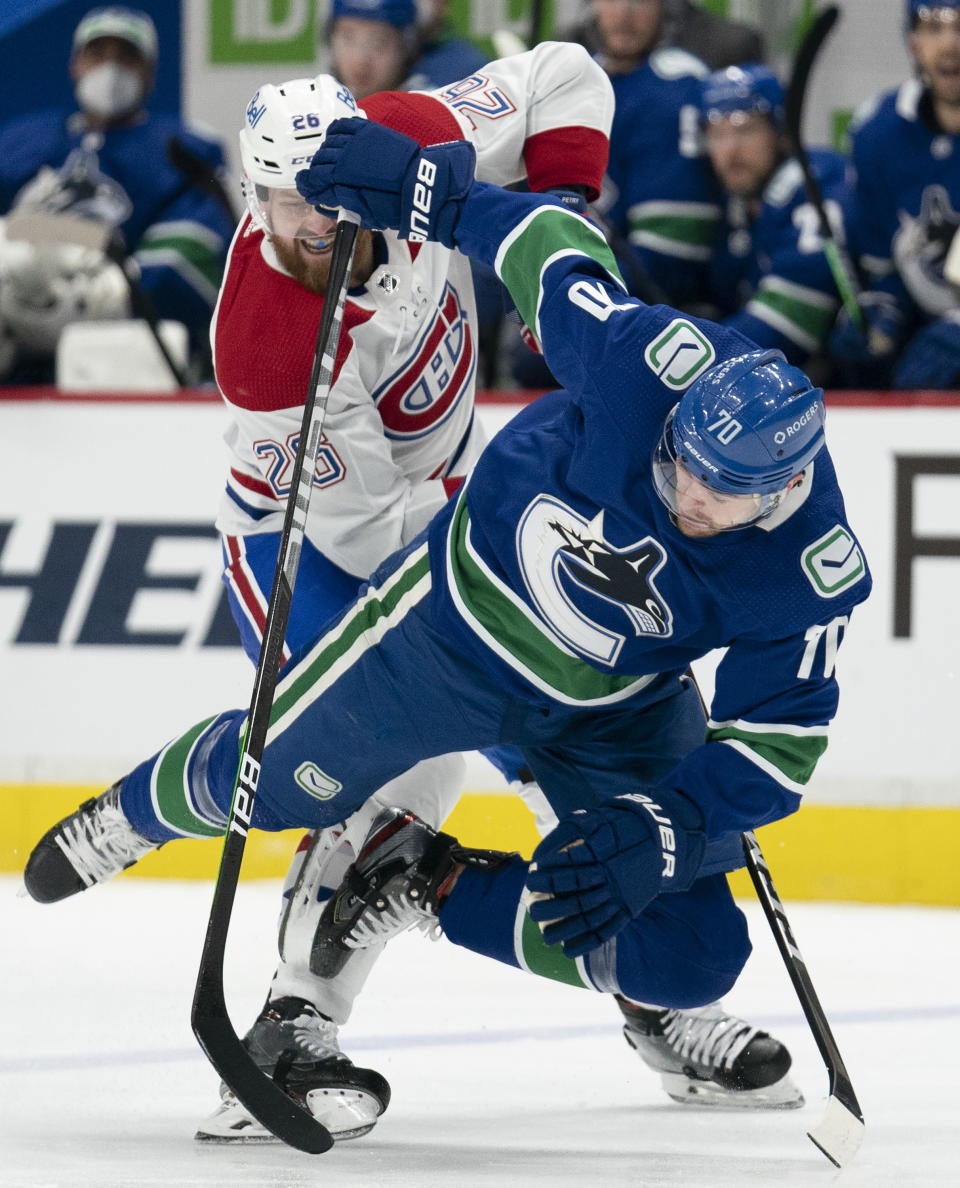 Montreal Canadiens defenseman Jeff Petry (26) fights for control of the puck with Vancouver Canucks left wing Tanner Pearson (70) during second-period NHL hockey game action in Vancouver, British Columbia, Monday, March 8, 2021. (Jonathan Hayward/The Canadian Press via AP)