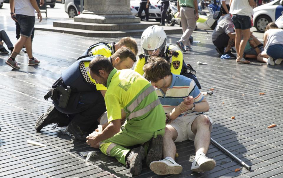 Police tend to one of the victims of Thursday’s attack (Rex)