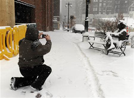 David Damroze braved the blizzard to photograph a snow-covered sculpture of Mark Twain sitting on a park bench during a heavy snowstorm that covered the metro area in downtown Kansas City, Missouri, February 4, 2014. REUTERS/Dave Kaup