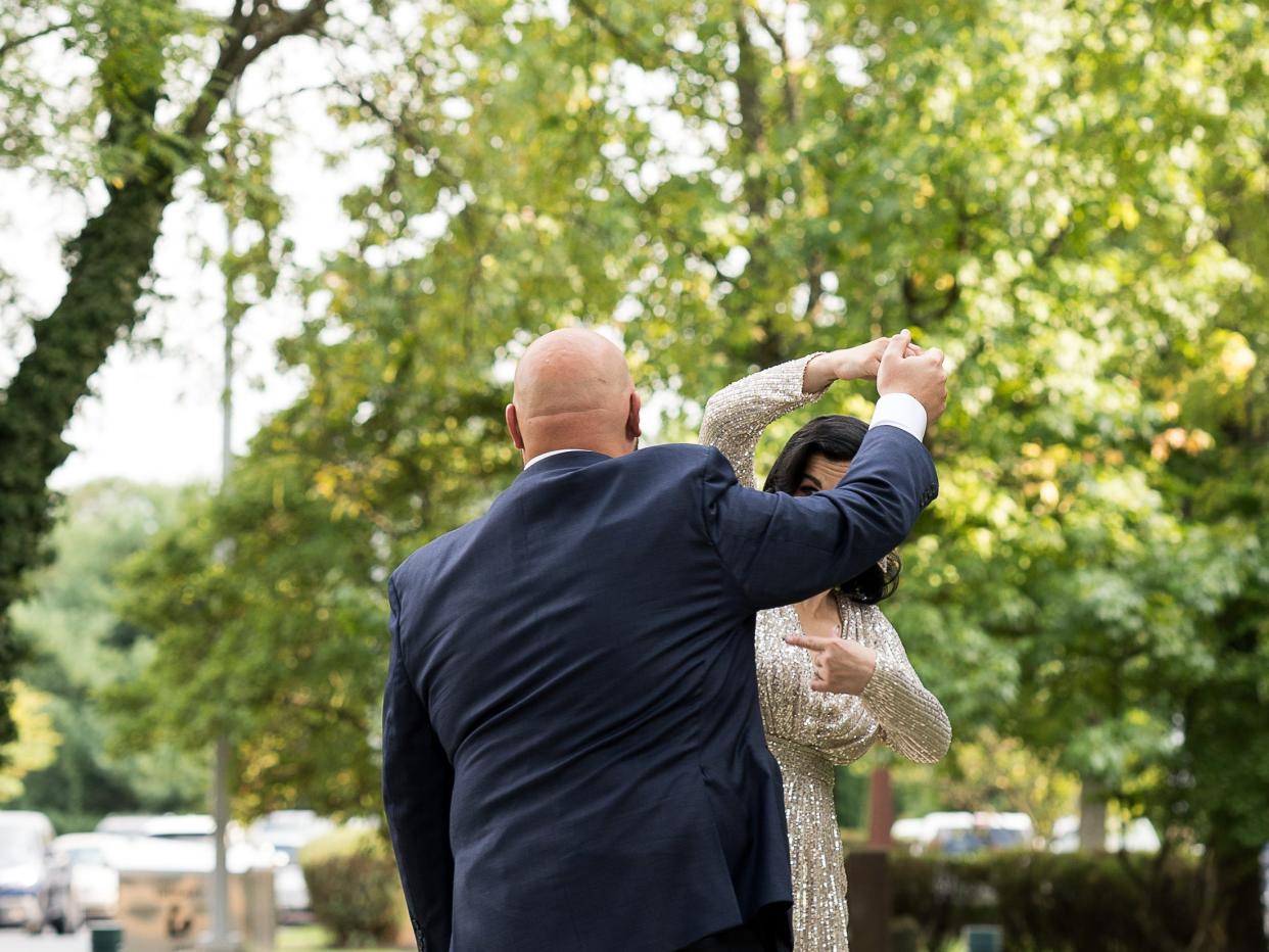 Zach Rocchino and his wife dancing on a sidewalk.