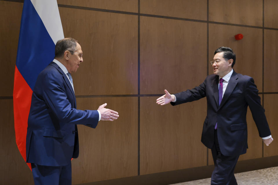 In this handout photo released by Russian Foreign Ministry Press Service, Russian Foreign Minister Sergey Lavrov, left, and Chinese Foreign Minister Qin Gang shake hands during their meeting in Samarkand, Uzbekistan, Thursday, April 13, 2023. (Russian Foreign Ministry Press Service via AP)