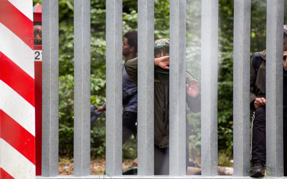 A Syrian migrant on the Belarusian side of the border wall with Poland