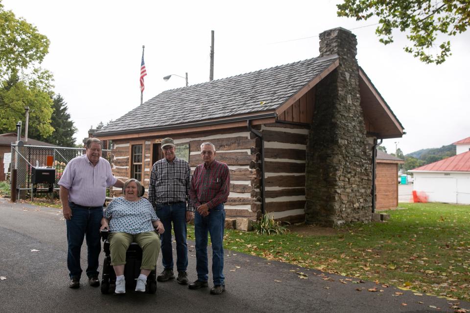 Lloyd and Diann Helber (left), of Lancaster, stand with Web Rice (middle) and Dave Benson outside of the renovated Pioneer Log House at the Fairfield County Fairgrounds on September 25, 2023, in Lancaster, Ohio. The Helbers donated money to the through the Fairfield County Foundation to restore the log house.