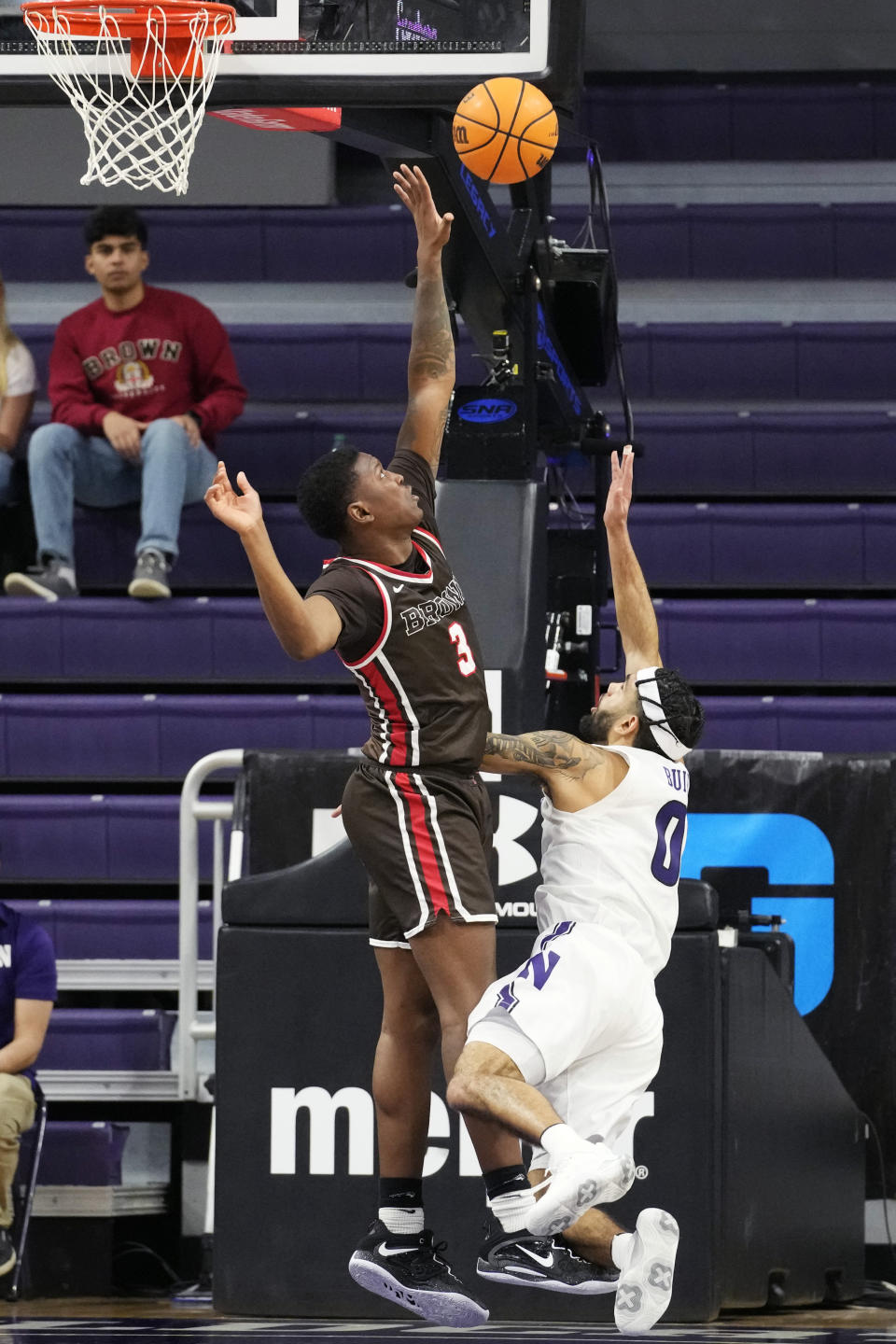 Northwestern guard Boo Buie, right, shoots over Brown guard Perry Cowan during the first half of an NCAA college basketball game in Evanston, Ill., Thursday, Dec. 29, 2022. (AP Photo/Nam Y. Huh)