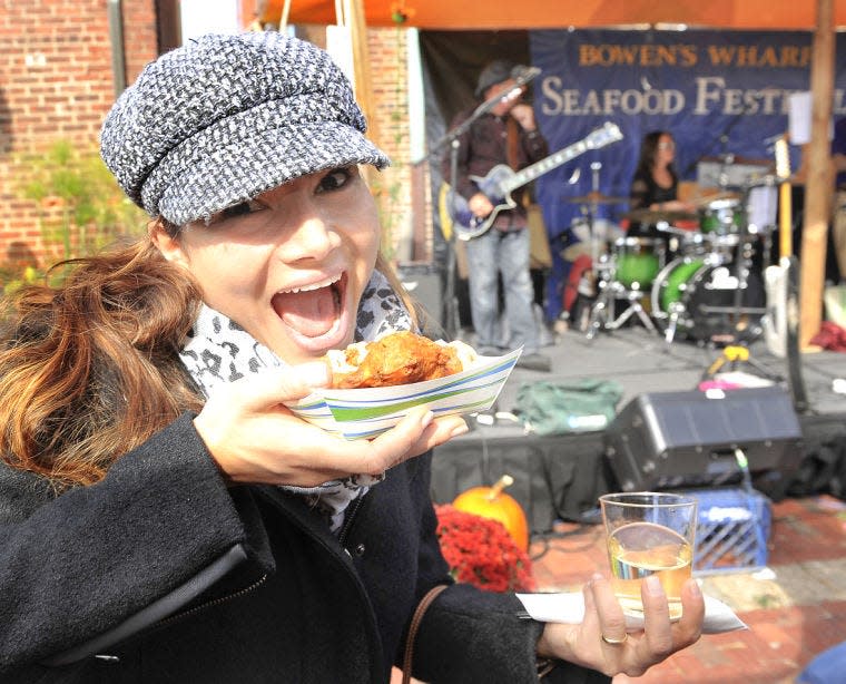 Josy Piacente of Brazil gets ready to dig into some shrimp fritters during the 2014 Bowen’s Wharf Seafood Festival in Newport.