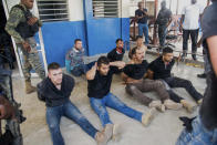 Police guard detained suspects in the assassination of Haiti's President Jovenel Moise at the General Direction of the police in Port-au-Prince, Haiti, Thursday, July 8, 2021. Moïse was assassinated in an attack on his private residence early Wednesday. (AP Photo/Jean Marc Hervé Abélard)