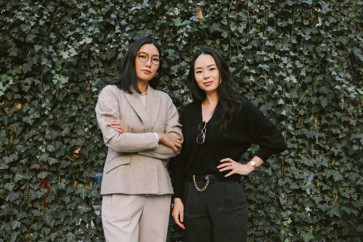 covry designers athina wang and florence shin stand in front of a wall full of ivy