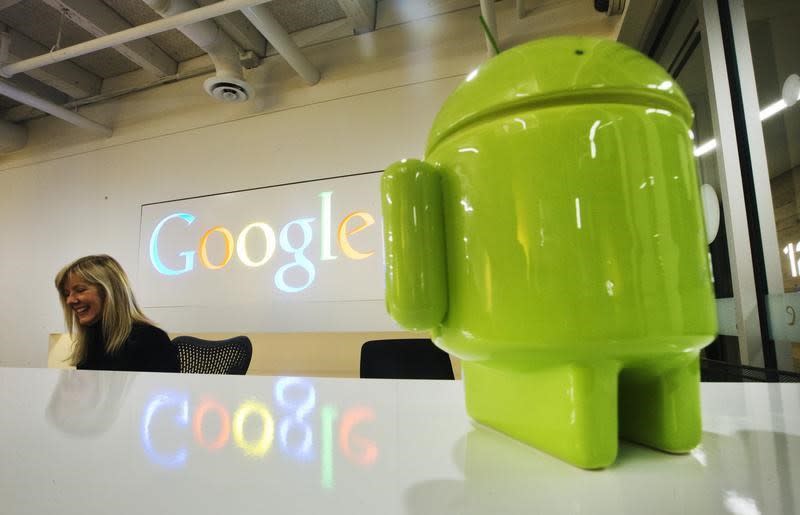 A Google Android figurine sits on the welcome desk as employee Tracy McNeilly smiles at the new Google office in Toronto, November 13, 2012. REUTERS/Mark Blinch/Files