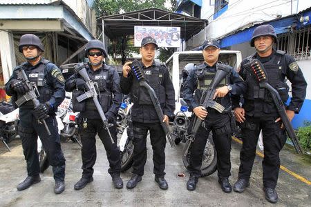 Members of the Philippine National Police Special Weapons and Tactics (SWAT) team pose for a picture outside a police station in Manila September 15, 2014. REUTERS/Romeo Ranoco