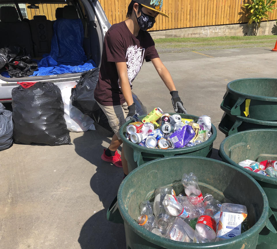 In this June 2021 photo provided by Maria Price, Genshu Price drops off cans and bottles at a recycling center in Kahaluʻu, Hawaii. Price has recycled over 100,000 cans and bottles to raise money for students' college tuition through his fundraiser, Bottles4College. (Bottles4College via AP)