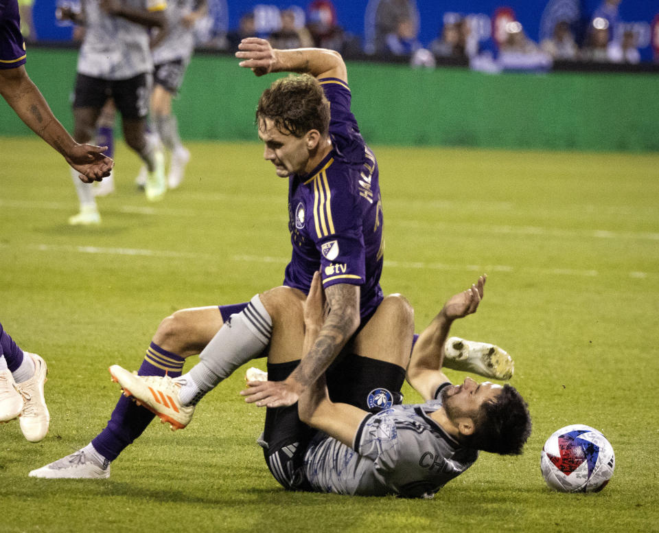 Orlando City defender Michael Halliday falls on CF Montreal midfielder Mathieu Choiniere during the first half of an MLS soccer game in Montreal, Saturday, May 6, 2023. (Allen McInnis/The Canadian Press via AP)
