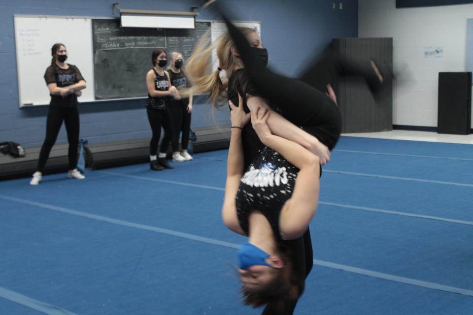 Cambridge High School dance team member Lainey Carpenter flips teammate Lilly Kuveikis,  during practice for the national dance competition.