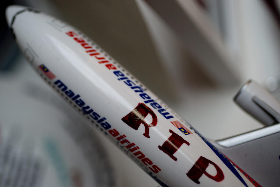 FILE - This Tuesday Sept. 9, 2014, file image shows a Malaysia Airlines miniature plane with a text reading "RIP MH17", displayed at a memorial site for the victims of the MH17 air disaster at Schiphol Airport in Amsterdam, Netherlands. A Dutch safety watchdog says airlines around the world need more and better information to make risk assessments about flying over conflict zones. The Dutch Safety Board issued a report Thursday Feb. 21, 2019, following up on its publication in 2015 of a probe into the cause of the downing of Malaysia Airlines Flight 17 over war-ravaged eastern Ukraine on July 17, 2014. (AP Photo/Peter Dejong, File)