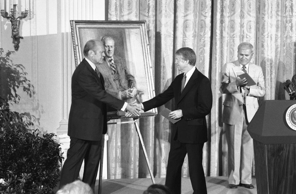 FILE - President Jimmy Carter shakes hands with former President Gerald R. Ford in the White House in Washington on May 24, 1978 during a ceremony at which a portrait of the former Chief Executive was unveiled. (AP Photo, File)