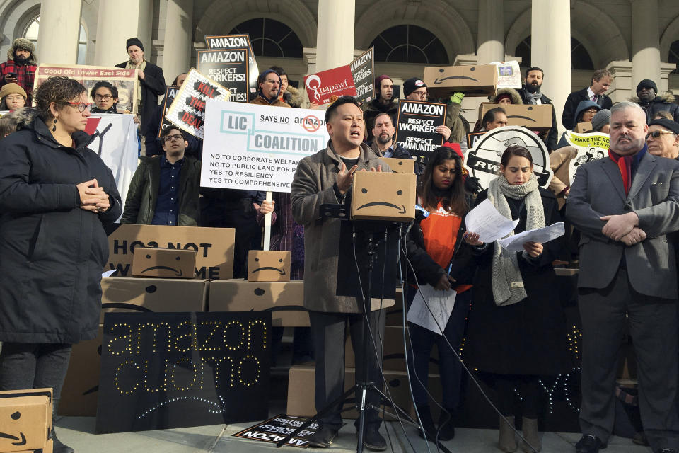FILE - This Dec. 12, 2018 file photo shows State Assemblyman Ron Kim, center, as he speaks at a rally opposing New York's deal with Amazon, on the steps of New York's City Hall. Gov. Andrew Cuomo warns that what he calls “political pandering” to critics of Amazon’s proposed secondary headquarters could sink New York’s biggest-ever economic development deal. But opponents say they’ll keep fighting a project they see as corporate welfare. Friday’s back-and-forth came after The Washington Post reported that Amazon is reconsidering its planned New York City headquarters because of opposition from local politicians. (AP Photo/Karen Matthews, File)