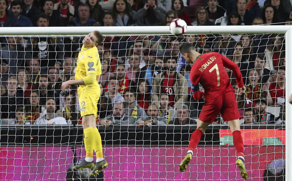 Cristiano Ronaldo (7), de Portugal, intenta un remate de cabeza durante un partido eliminatorio del Grupo B para la Eurocopa 2020 contra Ucrania, en el estadio de la Luz, en Lisboa, el viernes 22 de marzo de 2019. (AP Foto/Armando Franca)