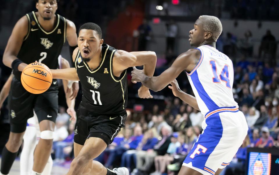 UCF Knights guard Tyem Freeman (11) drives against Florida Gators guard Kowacie Reeves (14) during the first half of the NIT tournament Wednesday, March 15, 2023, at Exactech Arena in Gainesville, Fla. Alan Youngblood/Gainesville Sun 