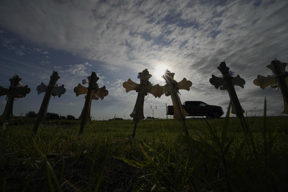 A truck passes crosses placed to honor the victims of the shooting at Robb Elementary School in Uvalde, Texas, Wednesday, May 3, 2023. Two teachers and 19 students were killed in the shooting. (AP Photo/Eric Gay)