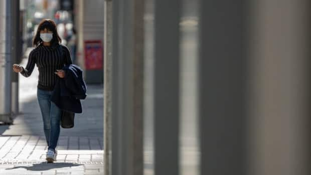 A woman wearing a mask walks through downtown Ottawa in April 2021 during the latest provincewide COVID-19 shutdown.