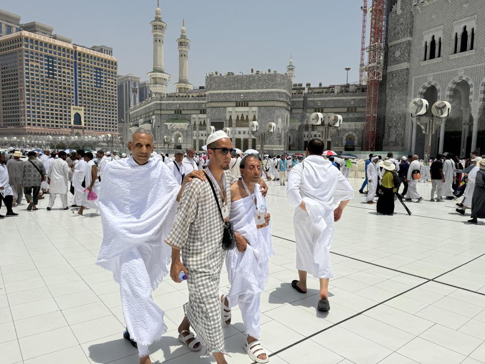 Two blind pilgrims preform Hajj with the help of their guide outside of the Grand Mosque during the annual pilgrimage in Mecca, Saudi Arabia, Thursday, June 13, 2024. Hajj is the annual Islamic pilgrimage to Mecca in Saudi Arabia that is required once in a lifetime of every Muslim who can afford it and is physically able to make it. Some Muslims make the journey more than once. (AP Photo/Baraa Anwer)