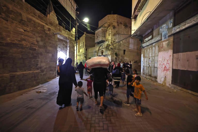 Familias palestinas en la calle después de evacuar sus hogares al este de Gaza.