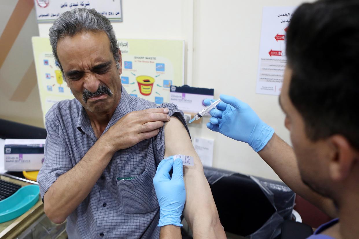 A Palestinian medical worker receives a Covi-19 vaccine at the Palestinian Red Crescent Hospital in the West Bank city of Hebron (EPA)