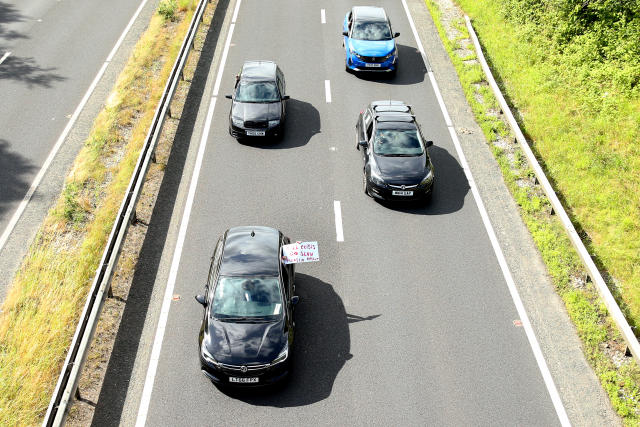 YORK, ENGLAND - JULY 04: Protesters hold up signs as they slow the traffic down on the A64 on July 04, 2022 in York, England. Prices for petrol and diesel have risen steadily this year as the price of oil has climbed, due to post-pandemic demand and sanctions against Russia, one of the world's largest oil exporters. (Photo by Cameron Smith/Getty Images)