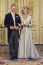 <p> For Camilla Parker Bowles&#x2019; long-awaited wedding to the heir of the British throne, she wore a light-blue chiffon dress beneath a blue-gold embellished coat&#x2014;both by designer Anne Valentine. Rather than wearing a crown, Camilla went with an intricate headdress made of golden feathers by Ellen Tracey. </p>