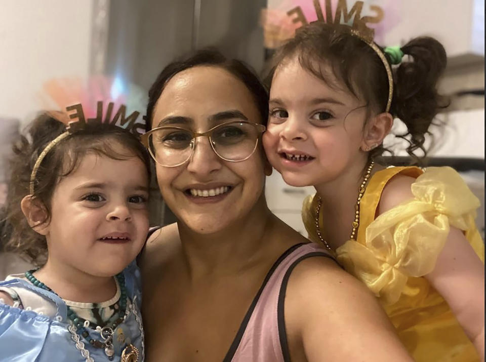 This undated photo provided by Hostages and Missing Families Forum Headquarters shows Sharon Aloni Cunio, center, and her twin daughters, Emma and Yuli, 3 years-old, released Monday, Nov. 27, 2023, to Israel after 52 days in Hamas captivity. Cunio, 34, is the personal advisor for the Head of Ashkol Regional Council. Her husband, David, and his brother Ariel remain in Hamas captivity. (Hostages and Missing Families Forum headquarters via AP)