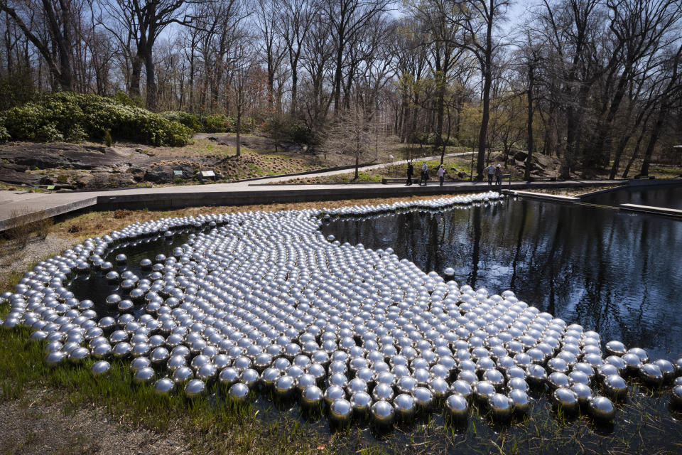Yayoi Kusama's installation of floating orbs, "Your Narcissism for Sale," is displayed at the New York Botanical Garden, Thursday, April 8, 2021 in New York. The expansive exhibit has opened, and ticket sales have been brisk in a pandemic-weary city hungry for more outdoor cultural events. (AP Photo/Mark Lennihan)