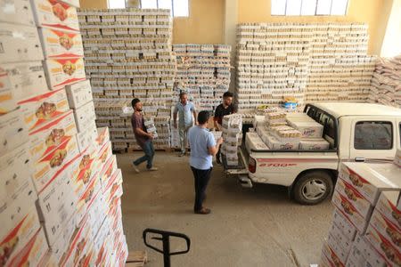 Workers load boxes of milk onto a truck at a market in the town of Zakho, Iraq October 11, 2017. REUTERS/Ari Jalal