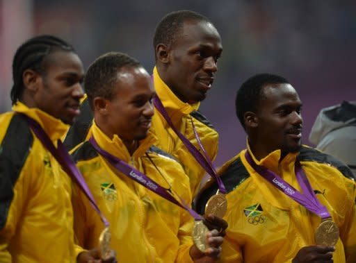 Los miembros del equipo de relevos jamaicano posan con su medalla de oro del 4X100, este sábado en Londres. (I-D) Yohan Blake, Michael Frater,Usain Bolt y Nesta Carter, en el podio. (AFP | johannes eisele)