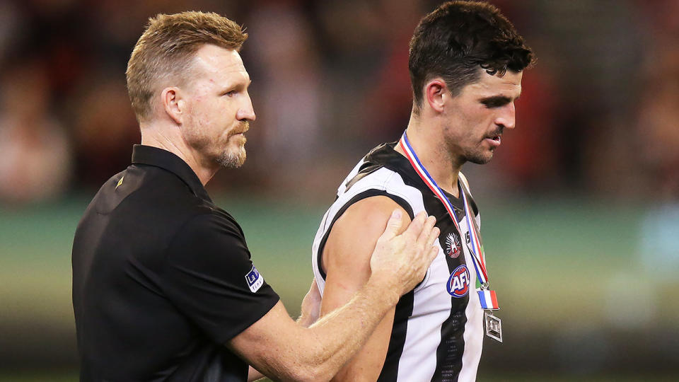 Magpies head coach Nathan Buckley walks off with best afield Scott Pendlebury of the Magpies after he was jeered by Bombers fans on receiving his medal. (Photo by Michael Dodge/Getty Images)