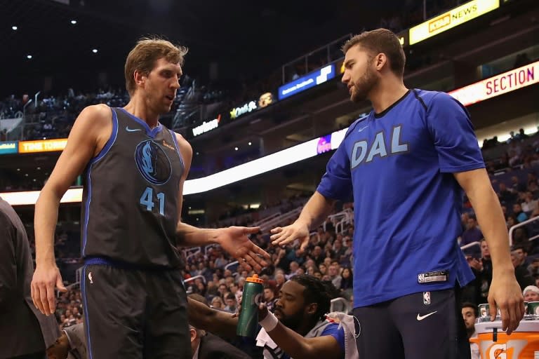 Dallas star Dirk Nowitzki greets teammate Maximilian Kleber after checking out of the first half of his first game of the NBA season against the Phoenix Suns