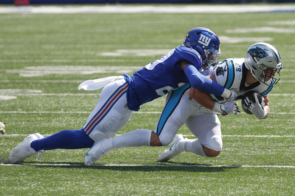 New York Giants' Julian Love, left, tackles Carolina Panthers' Christian McCaffrey during the first half an NFL football game, Sunday, Sept. 18, 2022, in East Rutherford, N.J. (AP Photo/Noah K. Murray)