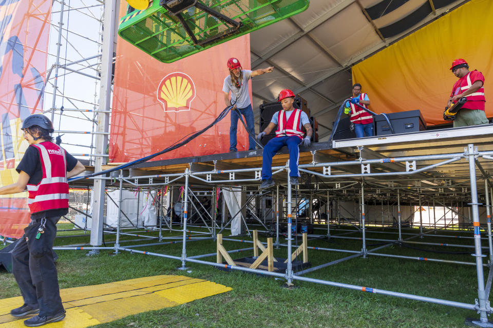 Sound and electrical crews move heavy wiring around the Festival Stage on Tuesday, April 23, 2024, in the final hours before the start of the New Orleans Jazz & Heritage Festival. (Chris Granger/The Times-Picayune/The New Orleans Advocate via AP)